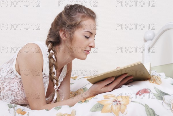 Attractive blond girl with hairdress reading the book