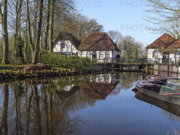 Painting of quiet houses with red roofs on the banks of a pond, surrounded by reflecting water and green trees, winterswijk, the netherlands