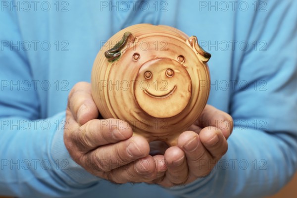 Senior holding piggy bank in hands