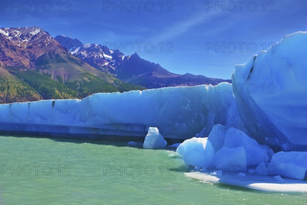 Ices and sun of Patagonia. White-blue huge icebergs float near a ship board. Excursion by tourist motor ship on Vyedm's lake