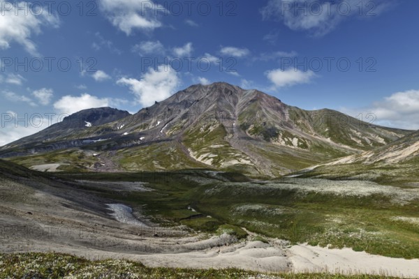 Summer mountain landscape of Kamchatka Peninsula: beautiful view of cone Khangar Volcano on sunny day. Eurasia, Russian Far East