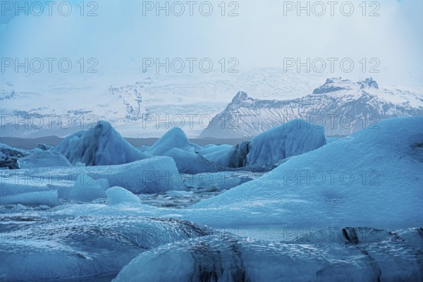 Serene icy landscape with blue glaciers and snowy mountains, with a cold wintry atmosphere, iceberg Iceland, glacier, snow, ice rock, ice diamont, glacier lagoon, nature, snow, diamont beach, Iceland, Europe