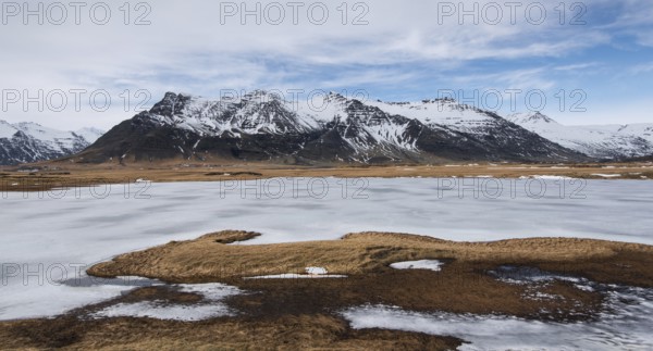 Typical Icelandic mountain landscape in Southeast Iceland with frozen lake