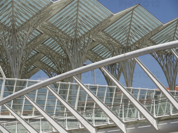 Architectural details of a modern structure with glass roof and steel construction against blue sky, Lisbon, portugal