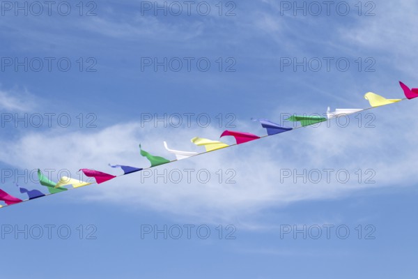 Multi-colored flags on a rope against the blue sky