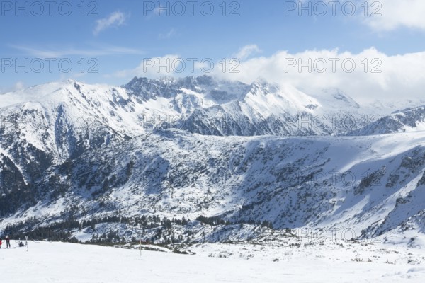 People skiing on alpine skis in mountains in ski resort Bansko, Bulgaria.