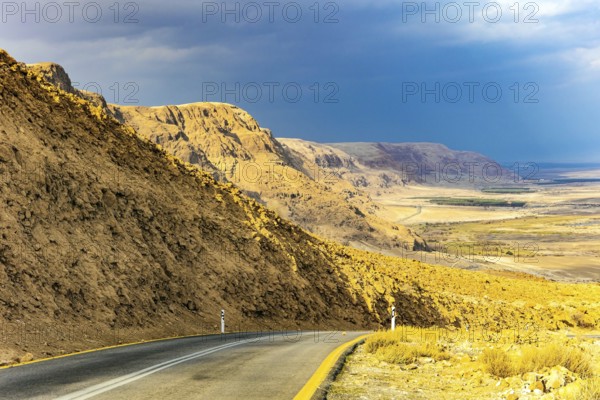 Wonder of nature - the Dead Sea. The highway runs along the coast of the Dead Sea. Cloudy and warm January day. Israeli coast of the Dead Sea