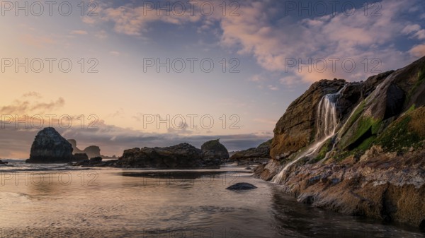 A seascape sunset with a waterfall at the beach. Humboldt County, California