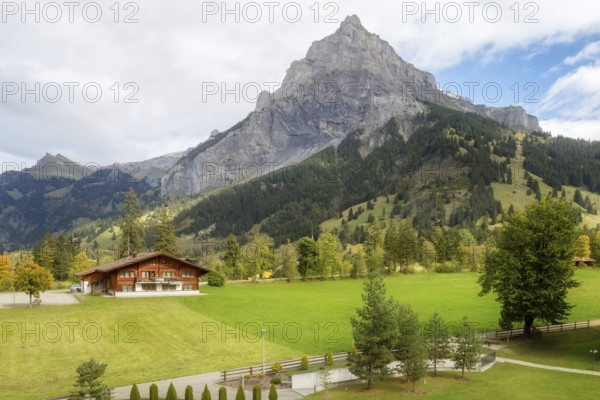Wooden chalet in Kandersteg village, Canton Bern, Switzerland, Europe, Autumn trees and mountains panorama, Europe