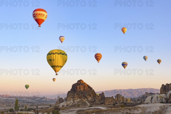 Flying hot air balloons and rock landscape at sunrise time in Goreme, Cappadocia, Turkey, Asia
