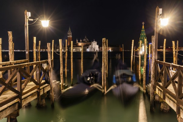 Venetian gondolas, boat dock at St Mark's Square, church of San Giorgio Maggiore in the background, night shot, Venice, Veneto, Italy, Europe