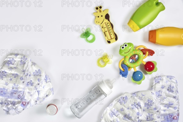 Set of accessories for baby. Pacifier, bottle, diaper, cream on white background. Maternal concept top view