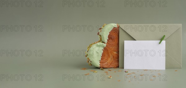 White empty mock up template paper note card Delicious fresh croissant topped with Matcha Green Tea flavor Ganache. Creation unique heart shape bakery. Puff pastry holiday love gift present idea Valentine's day. Copy space