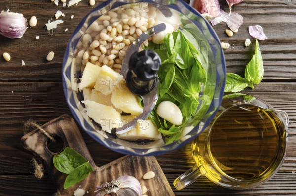 Ingredients for italian national traditional genovese pesto sauce in food processor bowl. Flat lay view