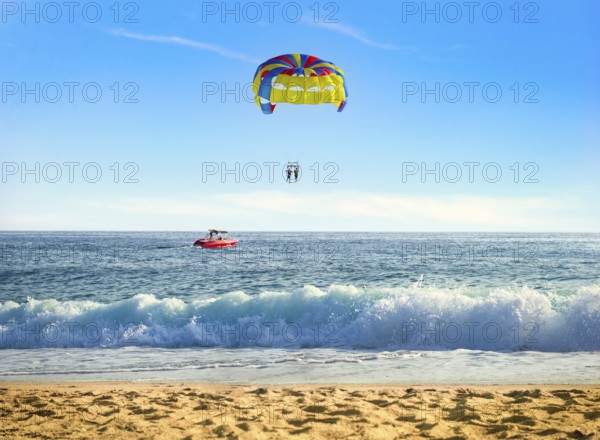 Parasailing over sea in sunny summer day