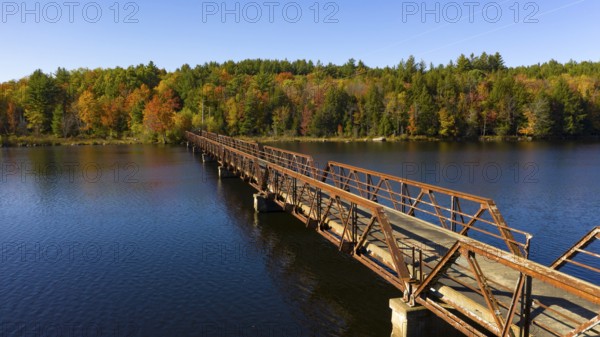 Fall color has begun to appear in the trees around a like in the Adirondacks