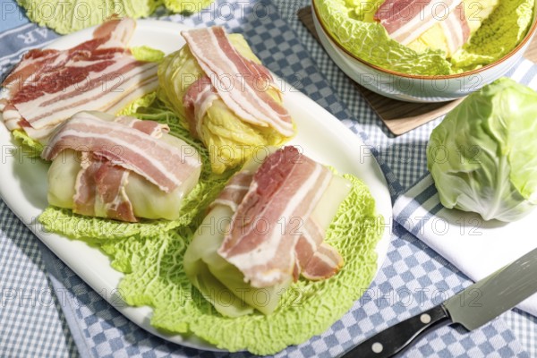 Preparation of savoy cabbage roulades with bacon on cabbage leaves