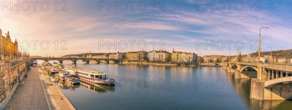 Colorful panorama with the Vltava river, its bridges and the buildings of Prague city, on a sunny day of March