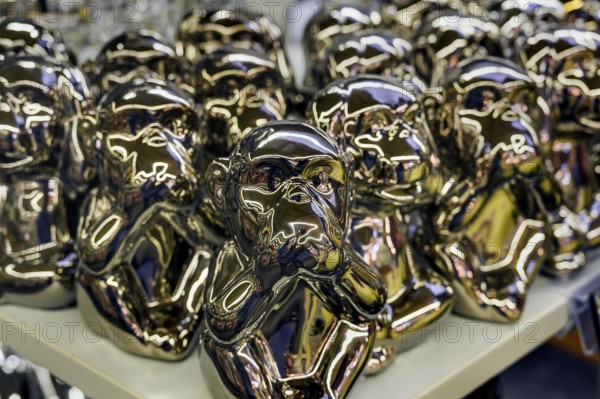 Monkey figures covering their mouths, a symbol of hearing, seeing and saying no evil, have become part of the Japanese folk belief Koshin. in a wholesale market, Allgäu, Bavaria, Germany, Europe