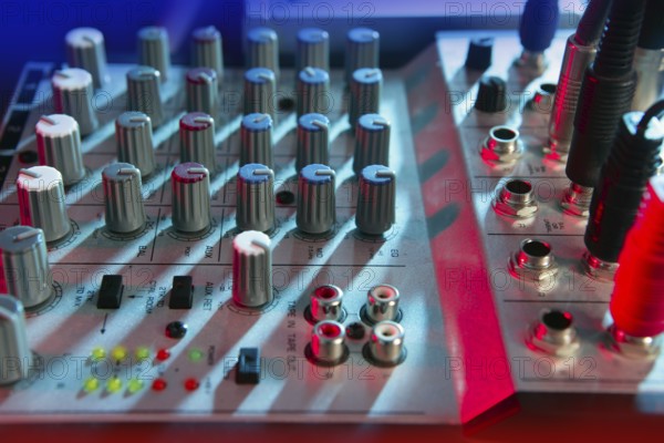 Audio mixer music desk under colorful lights equipment
