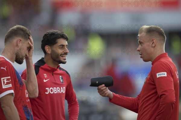 Football match, Eren DINKCI SC Freiburg centre laughing in conversation with former colleague Lennard MALONEY 1.FC Heidenheim right with shin guards in hand and captain Patrick MAINKA 1.FC Heidenheim holding his head, Voith-Arena football stadium, Heidenheim