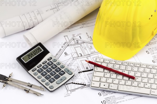 An architect's construction plan with a builder's helmet. Symbolic photo for financing and planning a new house