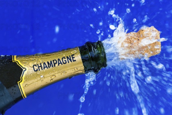 Champagne bottle is opened. Cork shoots out of champagne bottle. Symbolic photo for the turn of the year, New Year's Eve, celebrations and openings. Austria