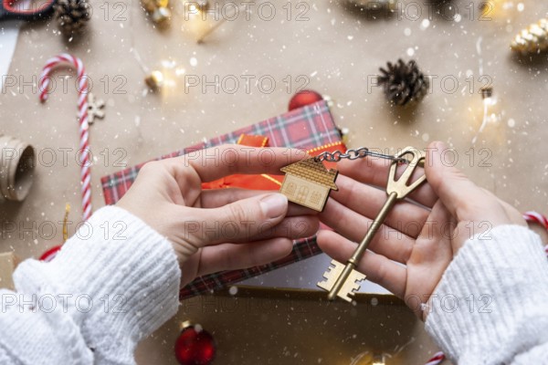 Key to house with keychain on cozy home in gift box with Christmas decor packaging. Pack present for New Year, Christmas. Building, project, moving to new house, mortgage, rent, purchase real estate
