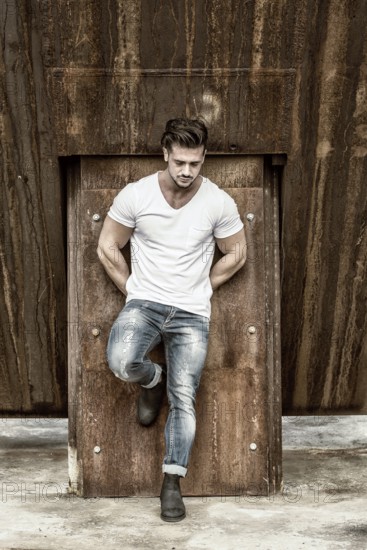 Attractive man in urban setting in front of big metal structure