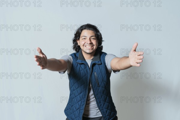 Happy young man welcoming with open arms isolated. Hospitable person opening arms to the camera