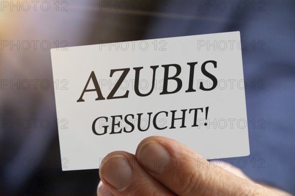 Trainee wanted: Close-up of a man with a business card AZUBI GESUCHT (symbolic image, composing)