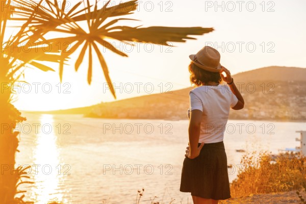 Panoramic view of the city and a tourist woman at sunset of Sarande or Saranda on the Albanian riviera, Albania