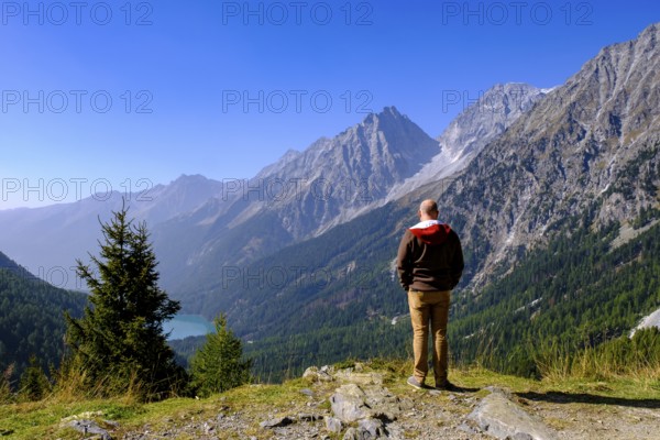 Hikers at the Staller Sattel, with Lake Antholz, behind Hochgall, between the Antholz Valley, South Tyrol Italy and the Defereggen Valley, East Tyrol, Austria