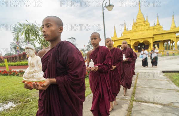 NAMSAI, INDIA.- APRIL 16: Buddhist monks carries the idol of Lord Buddha as they celebrate the vibrant Sangken Festival at Golden Pagoda in Namsai, India on 16 April 2025. Sangken Festival is a beautiful and culturally rich water festival celebrated primarily by the Theravada Buddhist communities, it marks the Buddhist New Year, typically falling in mid-April