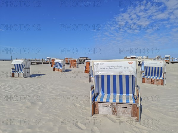 Preparing for the high season on the beach, setting up the beach chairs, North Sea, on the edge of the Wadden Sea National Park and UNESCO World Heritage Site, pile dwellings, sunshine and blue sky, SPO, Sankt Peter-Ording, Schleswig-Holstein, Germany