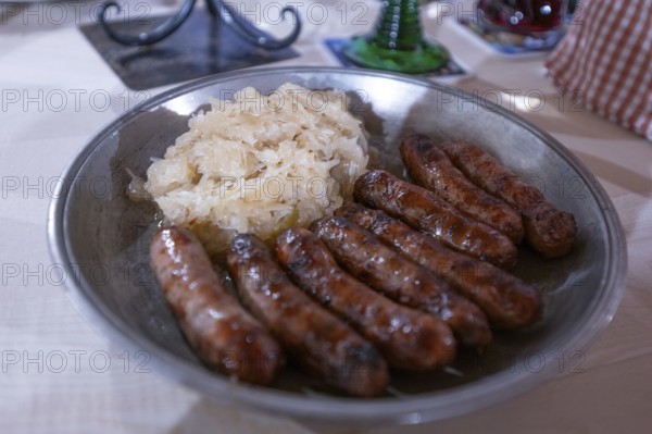 Nuremberg sausages with sauerkraut served on a pewter plate, Nuremberg, Middle Franconia, Bavaria, Germany