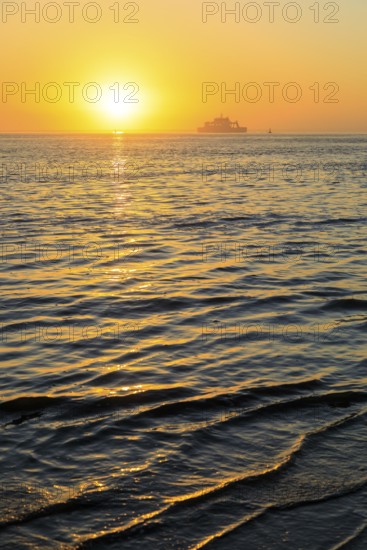 Ferry and sunset on the west coast of Norderney, Lower Saxony, Germany