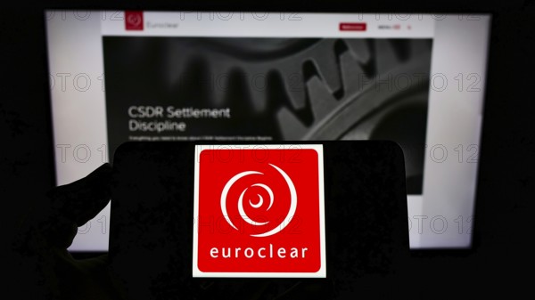 Stuttgart, Germany, 01-06-2022: Person holding cellphone with logo of Belgian financial company Euroclear Group on screen in front of business webpage. Focus on phone display
