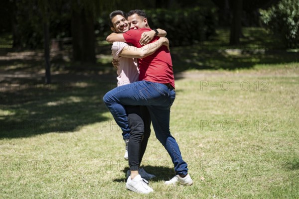 Couple of latin men hugging in a park