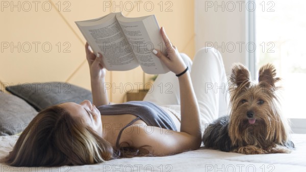 Woman with dog beside reading
