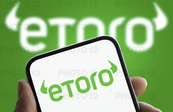 etoro logo is displayed on smartphone. eToro is a social trading and multi-asset investment company