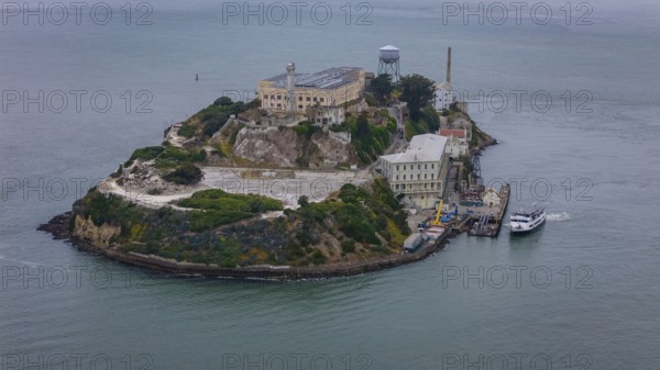 Aerial view of United States Penitentiary, Alcatraz Island, shows a historic maximum-security prison on a small island off San Francisco. Built in 1910-12, it operated from 1934 to 1963 and is now a major tourist attraction