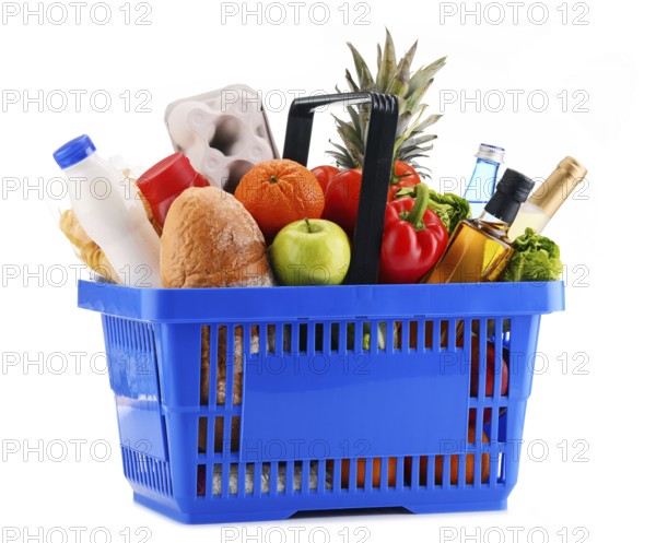Plastic shopping basket with assorted grocery products isolated on white