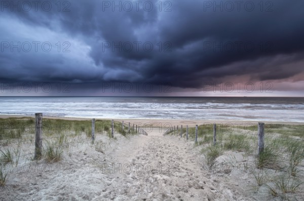 Stormy sky and showers over North sea beach, Netherlands