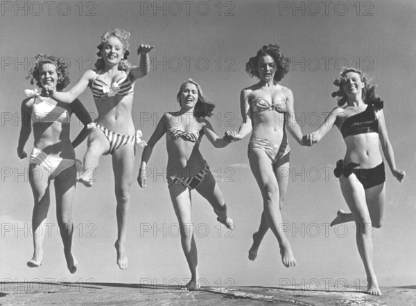 1940s summer. A group of young women in their bikinis are happy on this summer's day, jumping of joy. From left: Marianne Molander, Marianne Ljunggren, Eva Jönsson, Gunnel Wadner och Haide göransson. Photo Kristoffersson Ref AD26. Sweden 1947