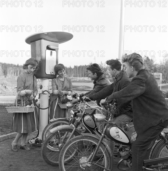 Teenagers of the 1950s. Three teenage boys at the petrol station that is being opened for the first time. The first customers are welcomed with flowers. Sweden 13 april 1958. Conard ref 3864