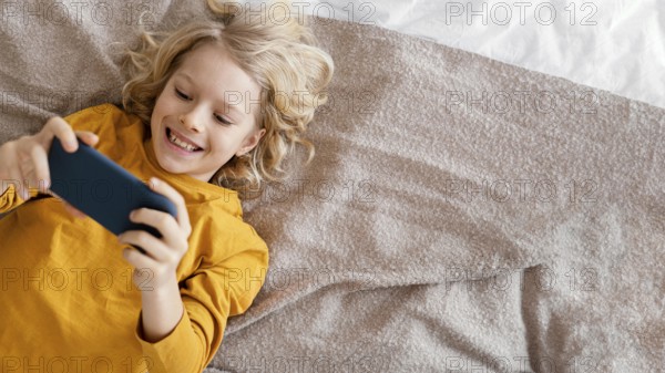 Boy bed playing mobile