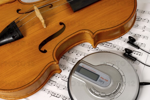 CD-player and a violin on sheet music