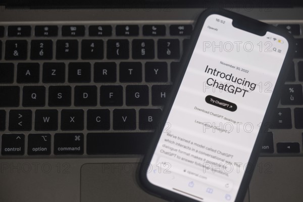 OpenAI software ChatGPT application on a mobile phone above a computer keyboard