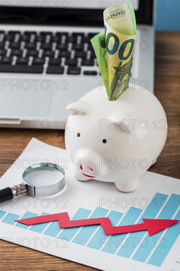 High angle office items with piggy bank growth chart